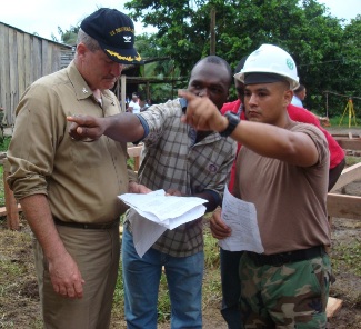  Left to right:  CAPT Rapp, USPHS Environmental Engineer; a village leader in La Sierpe, Colombia; and an interpreter look at plans used to install the waste water system.  CAPT Rapp provided recommendations to further improve the recently installed system.  Framing for the medical clinic can be observed in the background. 