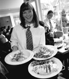 Photo of a waitress carrying three plates of food