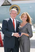 President George W. Bush presented the President's Volunteer Service Award to Sherri Goggin upon arrival in Marietta, Georgia, on Tuesday, July 22, 2008.  Goggin is the founder of Bundles of Joy, and a volunteer with Butterfly Dreams Farm Therapeutic Riding Program. To thank them for making a difference in the lives of others, President Bush honors a local volunteer when he travels throughout the United States.  He has met with more than 650 volunteers, like Goggin, since March 2002.