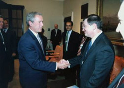 President George W. Bush greets National Communications System Deputy Manager Brenton C. Greene