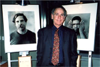 photo of photographer Michael Nye standing between two of his photographs on exhibit at SAMHSA