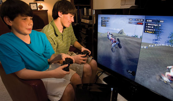 Photo of Alex and Andrew Turner playing a home video game.