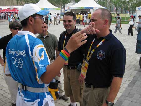 DS Special Agents ,left to right, Wendy Bashnan, Billy Alfano, Miguel Seau, and Al Luck discuss the arrival of US athletes with an Olympic volunteer at the Summer Games in Beijing, Aug. 14, 2008.