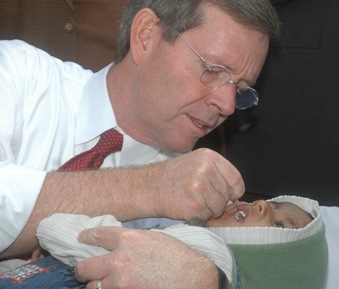 January 11, 2008 – U.S. Secretary of Health and Human Services Michael O. Leavitt administers oral polio vaccine to a small child at the Sriniwaspuri Maternal and Child Welfare Center in New Delhi, India, to show support for India's efforts to eradicate polio.