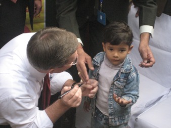 January 11, 2008 – U.S. Secretary of Health and Human Services (HHS) Michael O. Leavitt marks the finger of a young child he has just vaccinated against polio, during a National Immunization Days event at the Sriniwaspuri Maternal and Child Welfare Center in New Delhi, India.