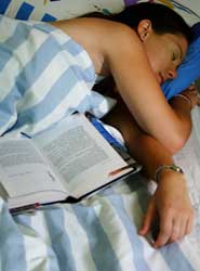 Photo of a girl sleeping with a open book next to her