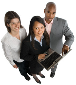 Image of three IT employees working with a laptop computer