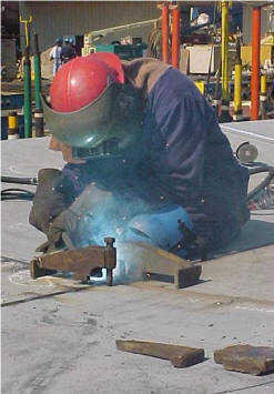 Photo of Shipworker working with full mask and other protective gear in the sun.