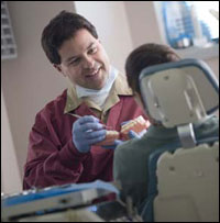 Dentist showing patient teeth model.