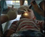 photo thumbnail: CAPT John Smith, a dentist, performs a dental procedure on a Vietnamese child at a Pacific Partnership dental civic action program.