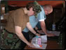 Photo Thumbnail: LCDR Steven Labrozzi, a pharmacist, reviews a prescription for a patient at the Huacho clinic in Peru.