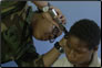 photo thumbnail: LT Tracy Branch checks the ear of a local patient during a medical screening