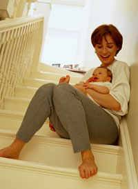 Photo of woman sitting on stairs holding infant