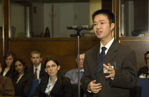 Student standing at microphone placed in audience seating addesses question to Under Secretary Dobriansky