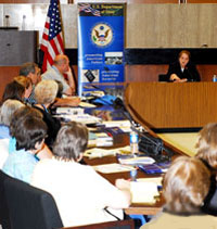 Teachers sit at conference tables facing speaker, Deputy Assistant Secretary Alina Romanowski. State Dept. photo