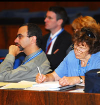Educators sitting at conference table, listening and taking notes