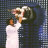 man mounting microwave horn on a base surrounded by foam rubber in an antenna range.
