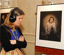 A photography exhibit on hurricane survivors at the Spirit of Recovery conference included an audio presentation in the survivor's own voice. A conference participant listens with earphones