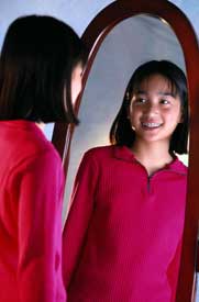 Photo of girl looking in the mirror and smiling