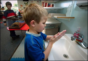 Photo: A young boy washing his hands.