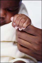 Photo: An infant grasping a mother's finger