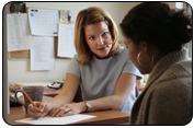 photo of a health educator at a desk talking to a patient seated near her