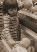 child placing fruit in toy shopping cart