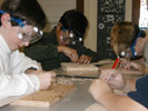 Students carefuly cut the glider parts from balsam wood