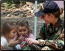 Photo Thumbnail: LT Elizabeth Leavitt, a health services officer, takes a break to enjoy a moment with local El Salvadoran kids.