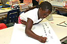 Naijah Woods, a fifth grader at Stearley Heights Elementary School on Kadena Air Base in Okinawa, Japan, puts finishing touches on a poster she will carry during her school's 9/11 Freedom Walk. Defense Dept. photo by Charles Steitz