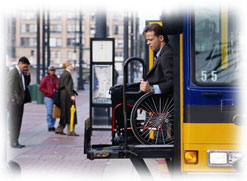 Photograph of a man in a wheel chair exiting a bus.