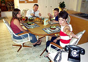 Picture of family at dinner table while telephone is ringing