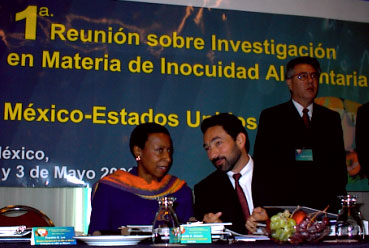 Photograph of Camille Brewer speaking with another meeting attendee during the workshop.