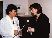 Photo: Hong Kong 1997--Dr. Lim, who first cultured the then rare H5N1 strain, discusses results with CDC EIS officer, Dr. Carolyn Bridges.