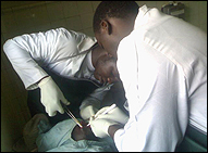 Photo: Christopher Odero and Fredrick Otieno work on an injured man at the Provincial General Hospital.