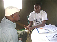 Photo: Fredrick Miruka speaks to a patient during the medical camp