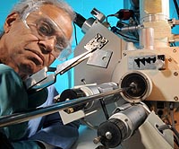 Argonne's Ken Natesan examines an example of corroded alloy and a new alloy created by his team at U.S. Department of Energy's Argonne National Laboratory