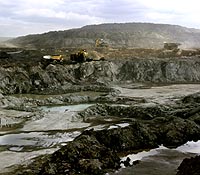 Open pit mining uses shovels and large trucks to remove oil sand