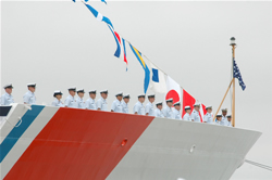 The crew of the USCG Cutter Bertholf man the rails during the commissioning ceremony on Coast Guard Island
