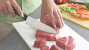 hands slicing meat