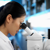 Figure: Scientist peering into microscope.
