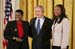 President George W. Bush is joined by Joan Thomas of Smyrna, Ga., left, and Erica Turner, who was mentored by Thomas, after Thomas received the President's Volunteer Service Award at a White House celebration of African American History Month on February 22, 2006.