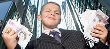 A boy in a suit holding a lot of money.