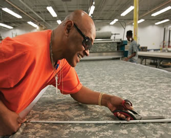 JWOD Employee measuring military garment material