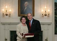 President Bush presents the President's Volunteer Service Award to Navy spouse Ellen Patton from Naval Base Point Loma, California, before the White House celebration of  Military Spouse Day on Tuesday, May 6, 2008.  During her 26 years as a military spouse, Patton has moved 20 times to 13 duty stations from Hawaii to Virginia.  She is a volunteer quilt maker for the Quilts of Valor Foundation, which provides quilts to wounded and injured service members and veterans from the Global War on Terror throughout the country and abroad.  In addition, Ellen volunteers with West Point’s Plebe Network as an online mentor for parents of cadets, and she helps prepare the winter shelter for homeless veterans with the Veteran’s Village of San Diego.