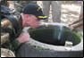Photo thumbnail: CDR Andrew Smith, an environmental engineer, assesses the quality of a water sample from a water well at the Escuela Santa Isabel in Escuintla in the Republic of Guatemala. 