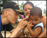 photo thumbnail: CDR Izune Hwang, a family-practice physician, performs an ear exam with an otoscope to determine if a suspected ear infection is due to fever, ear pain, or hearing loss.