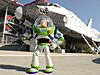Buzz Lightyear standing in front of a space shuttle orbiter