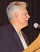 Side profile of Rudolfo Anaya at the microphone