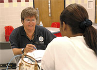 photo of a FEMA representative helping a resident affected by Hurricane Katrina